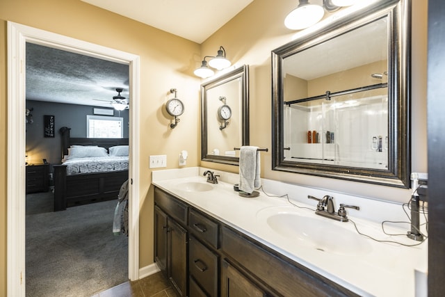 bathroom with a textured ceiling, ceiling fan, and double vanity