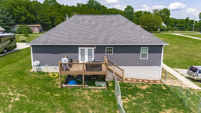 back of house with a deck, an outdoor structure, and a lawn