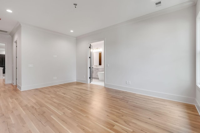 empty room with crown molding and light hardwood / wood-style floors