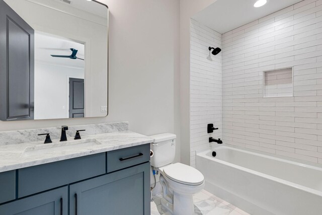 full bathroom featuring tiled shower / bath, vanity, and toilet