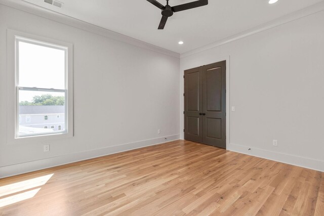 empty room with ceiling fan, ornamental molding, and light wood-type flooring