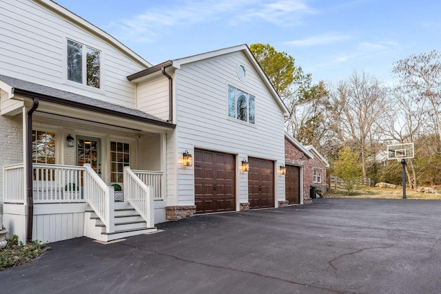 view of home's exterior with a garage and a porch