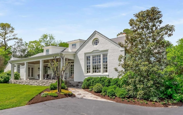 view of front of home with covered porch and a front yard