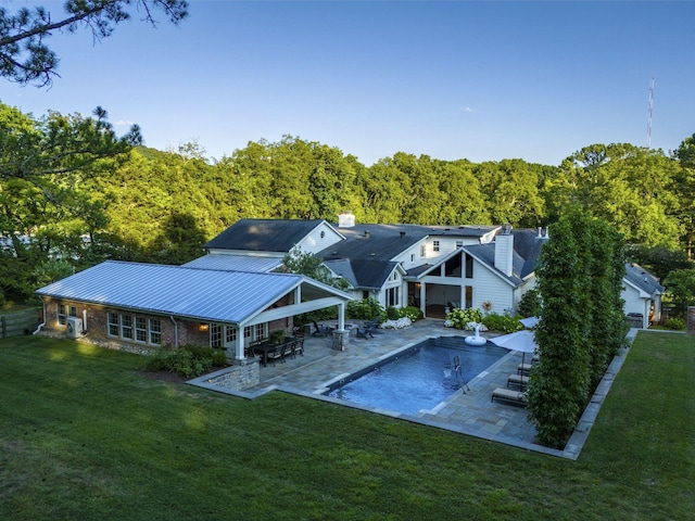 back of property featuring a patio and a yard