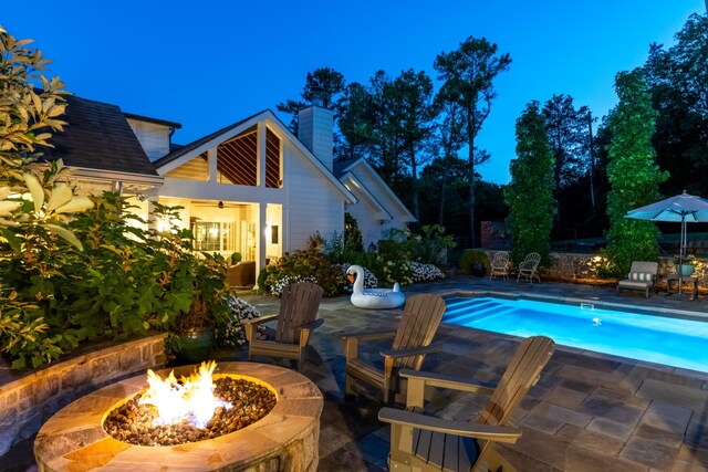 view of swimming pool featuring an outdoor fire pit and a patio