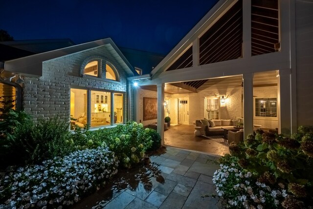 back house at twilight featuring a patio and an outdoor hangout area