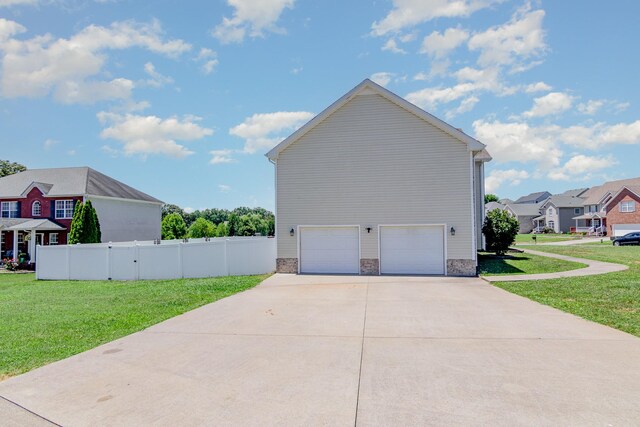 view of side of property featuring a garage and a yard