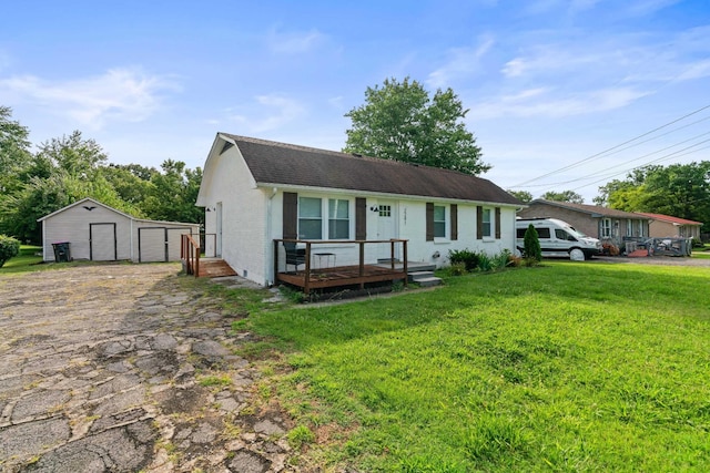 view of front of home with a garage, an outbuilding, and a front lawn