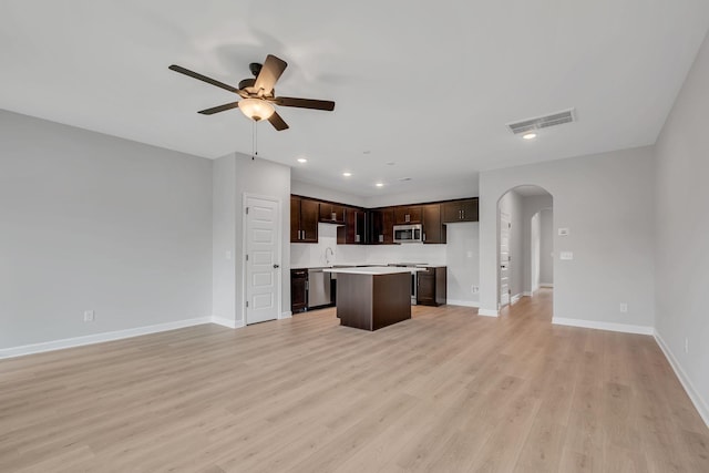 unfurnished living room featuring ceiling fan, sink, and light wood-type flooring