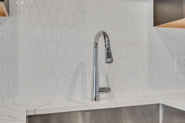 interior details featuring tasteful backsplash and sink