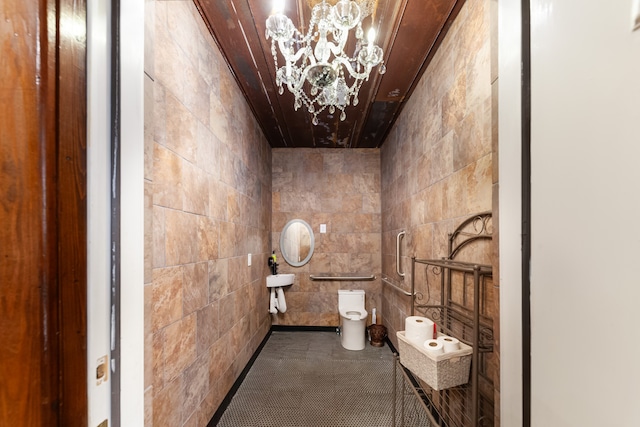 bathroom featuring an inviting chandelier and toilet