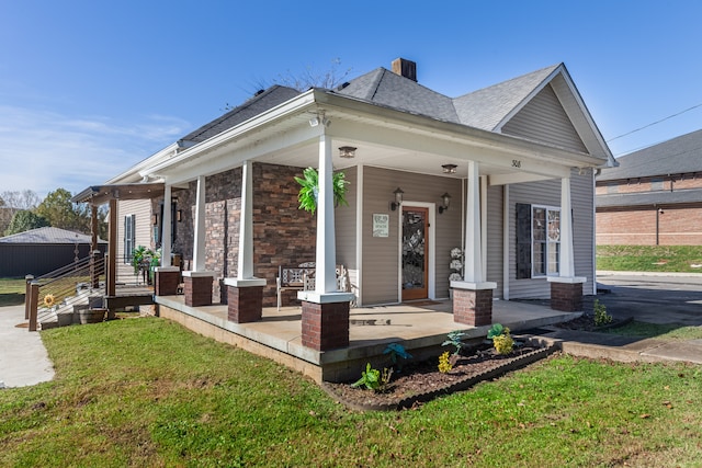 back of house featuring a yard and a porch