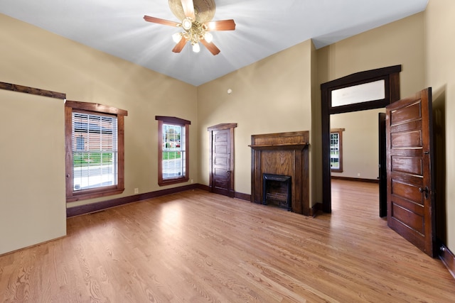 unfurnished living room with a high end fireplace, light hardwood / wood-style flooring, and ceiling fan