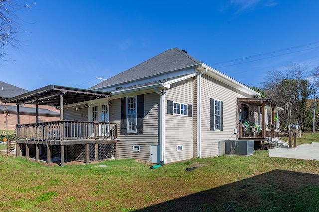 back of property featuring a wooden deck and a yard