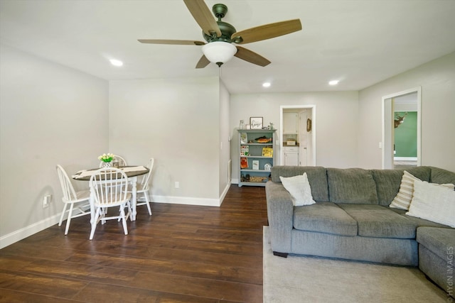 living room featuring ceiling fan and dark hardwood / wood-style flooring