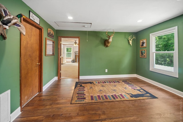 spare room featuring a healthy amount of sunlight and dark hardwood / wood-style floors