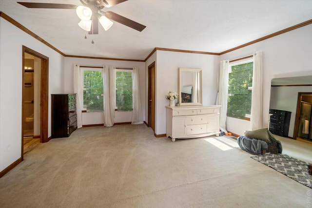 bedroom with ceiling fan, light colored carpet, ensuite bathroom, and crown molding