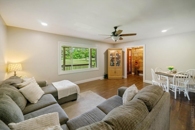 living room with ceiling fan and dark hardwood / wood-style floors