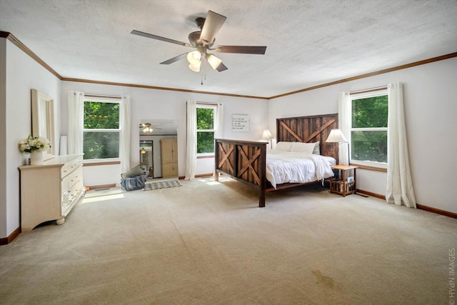 unfurnished bedroom with ceiling fan, multiple windows, light carpet, and a textured ceiling