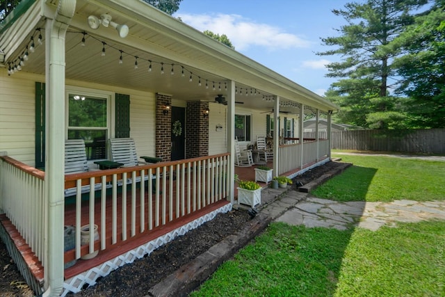 view of side of home with ceiling fan, a lawn, and a porch