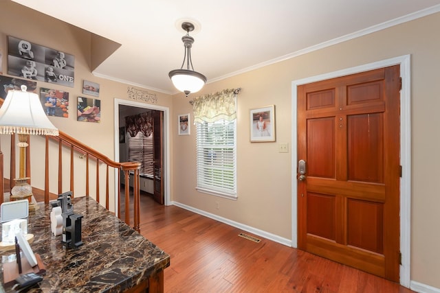 foyer featuring ornamental molding and hardwood / wood-style floors