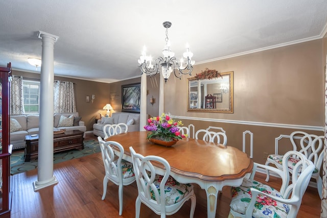 dining space featuring dark hardwood / wood-style flooring, ornamental molding, and ornate columns