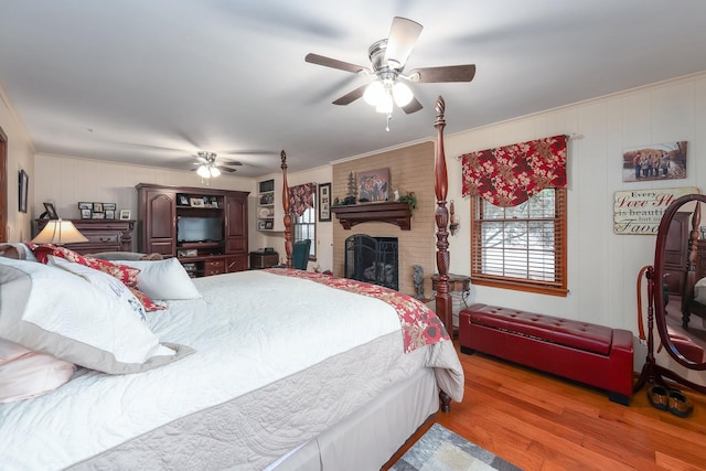 bedroom with ceiling fan, light hardwood / wood-style floors, ornamental molding, and a fireplace