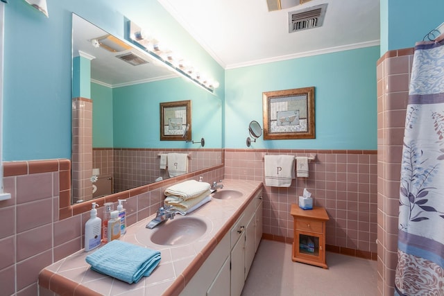 bathroom with tile patterned flooring, vanity, tile walls, and ornamental molding