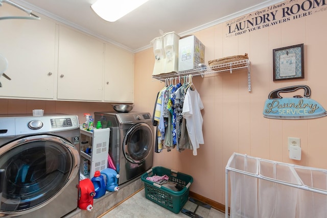 laundry room featuring washing machine and dryer, cabinets, and ornamental molding