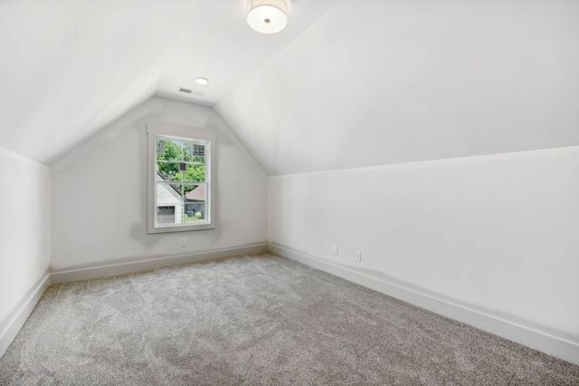 bonus room featuring vaulted ceiling and carpet flooring