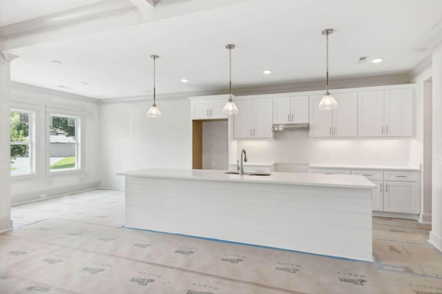 kitchen with sink, an island with sink, white cabinets, and decorative light fixtures