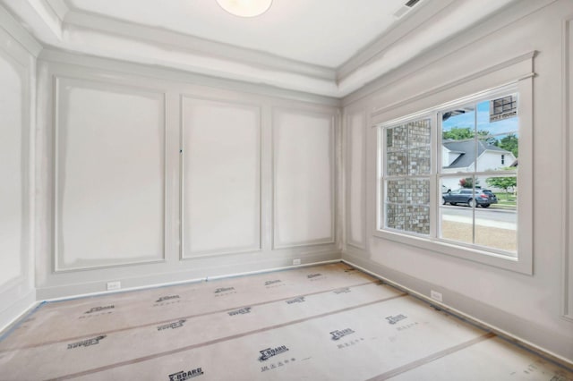 interior space featuring a raised ceiling and crown molding