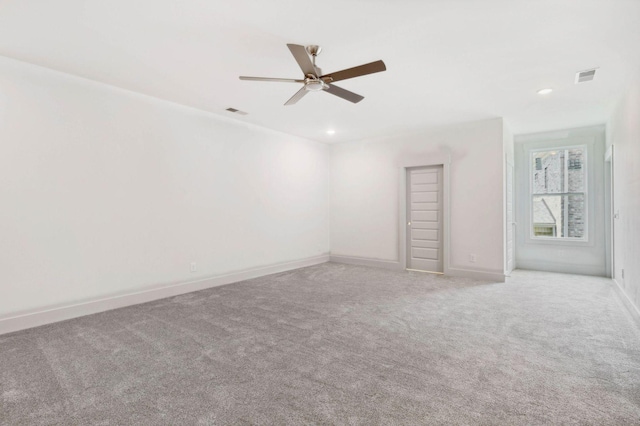 carpeted spare room featuring ceiling fan