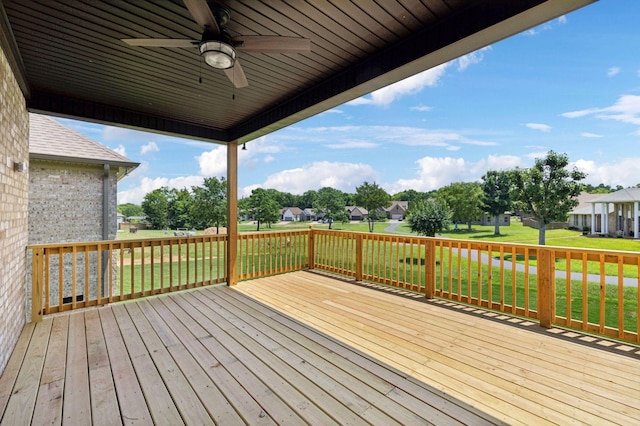 wooden terrace featuring a yard and ceiling fan