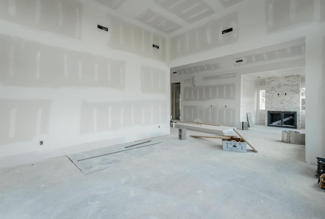 unfurnished living room featuring a stone fireplace