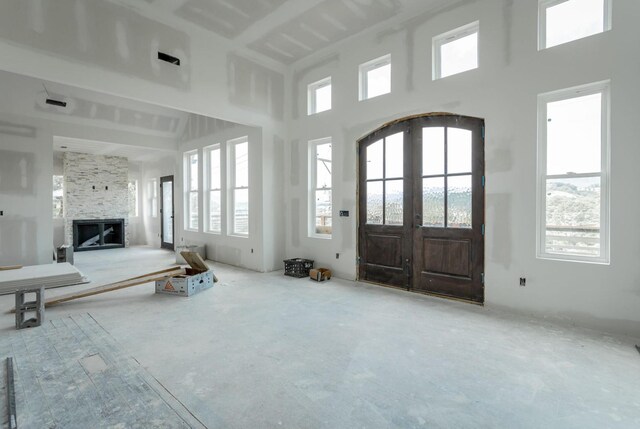 interior space featuring a large fireplace, french doors, and plenty of natural light