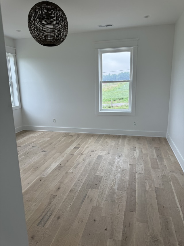 empty room with light hardwood / wood-style flooring and a healthy amount of sunlight