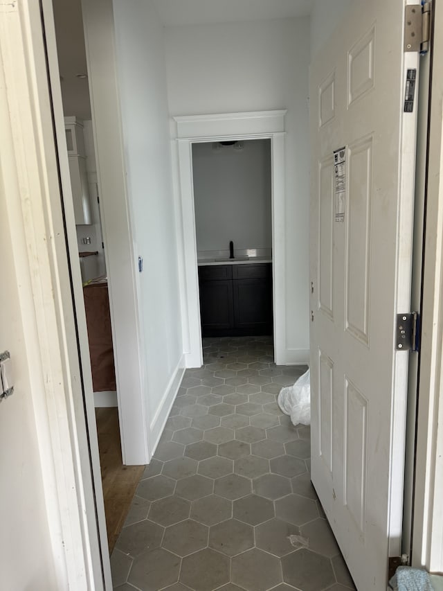 hall featuring sink and tile patterned flooring