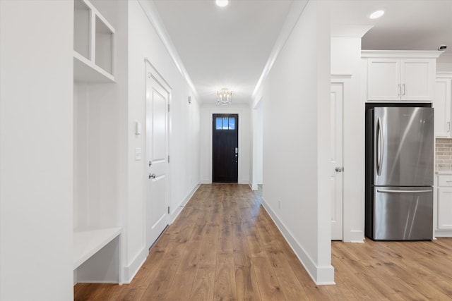 hallway featuring crown molding and light wood-type flooring