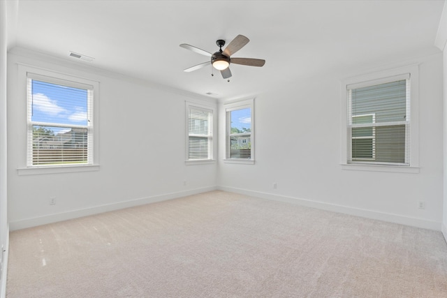 spare room featuring crown molding, ceiling fan, and light carpet