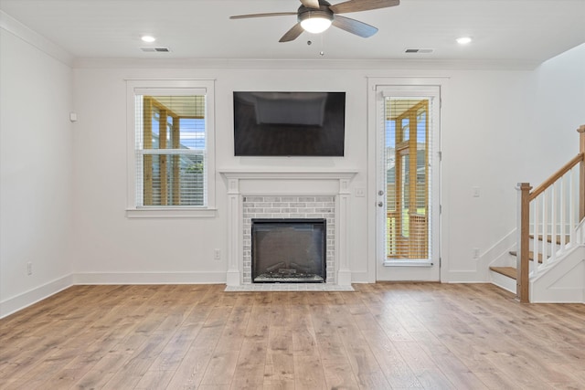 unfurnished living room featuring crown molding, a healthy amount of sunlight, and light hardwood / wood-style floors