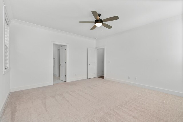 unfurnished bedroom featuring ornamental molding, light colored carpet, and ceiling fan