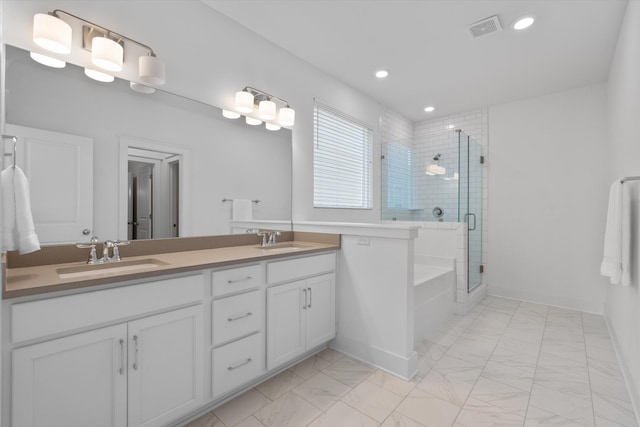 bathroom with vanity and shower with separate bathtub