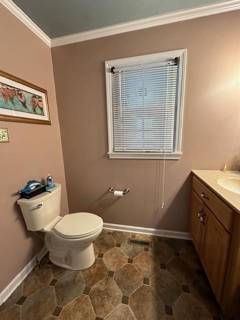 bathroom featuring toilet, vanity, and ornamental molding