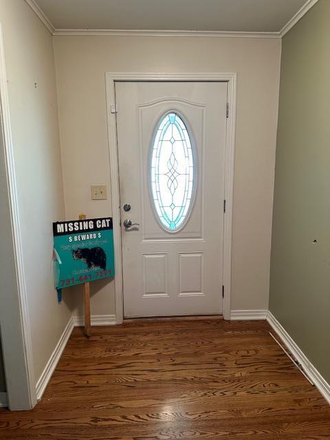 entryway with ornamental molding and dark wood-type flooring