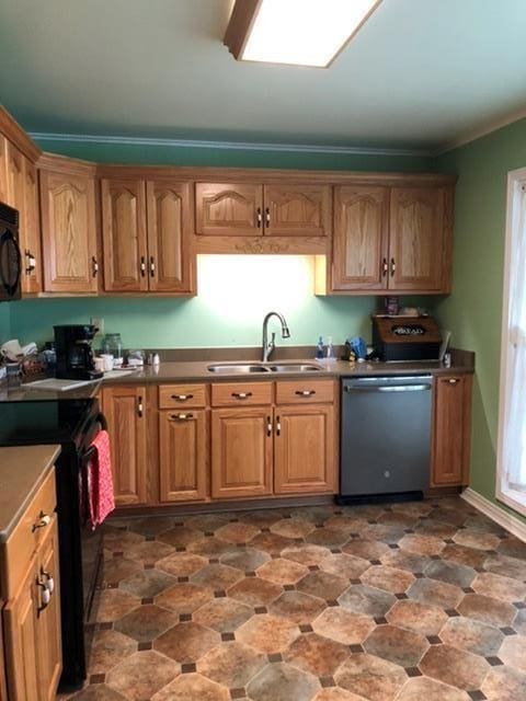 kitchen featuring black appliances, ornamental molding, and sink