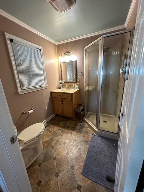 bathroom featuring vanity, a shower with shower door, ornamental molding, and toilet