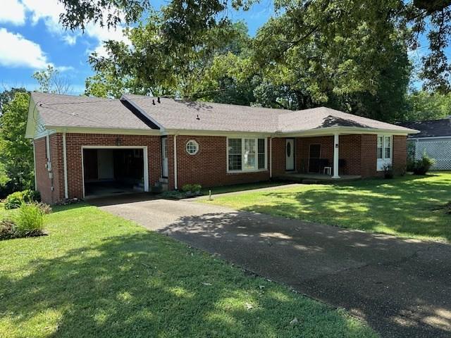 ranch-style house with a garage and a front yard