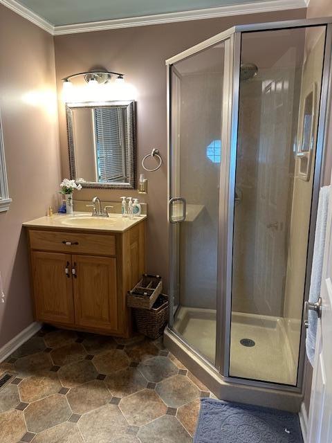 bathroom with ornamental molding, a shower with door, and vanity