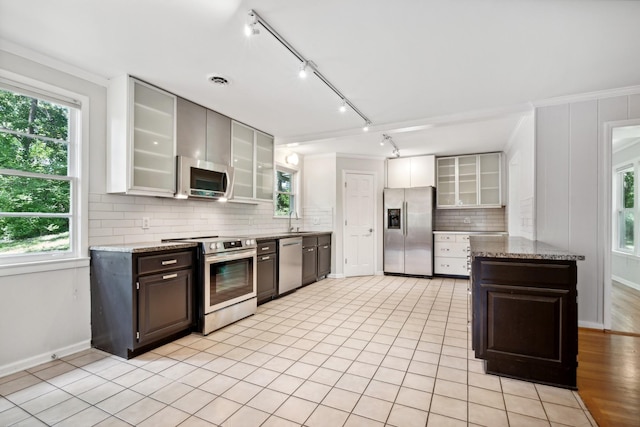 kitchen featuring sink, stainless steel appliances, dark brown cabinetry, and ornamental molding